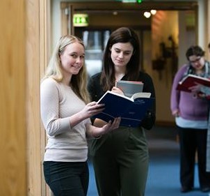 Two students reading a textbook together